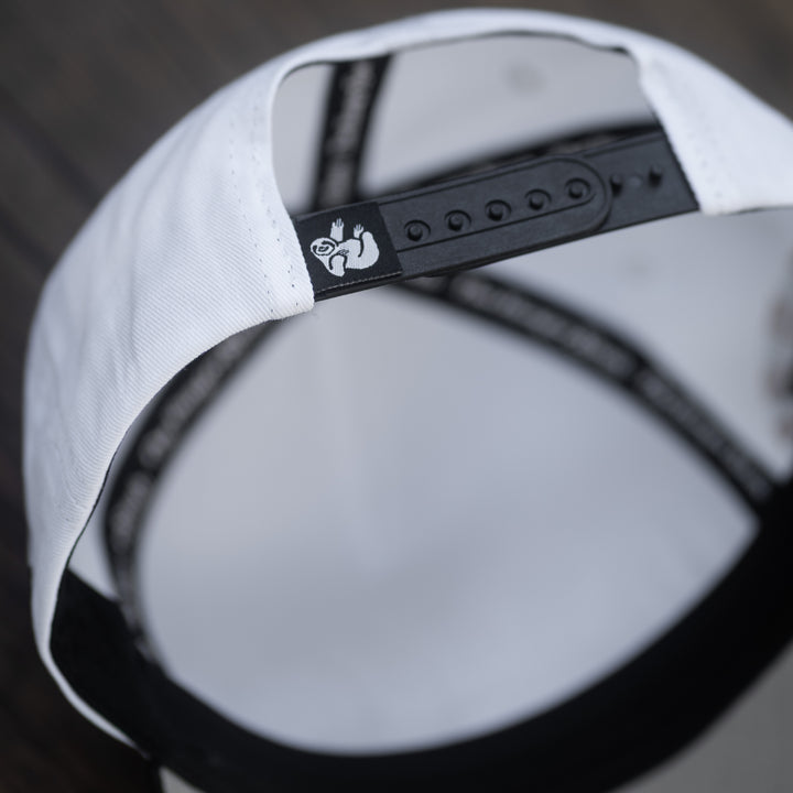 white snapback hat with the hungry sloth branding