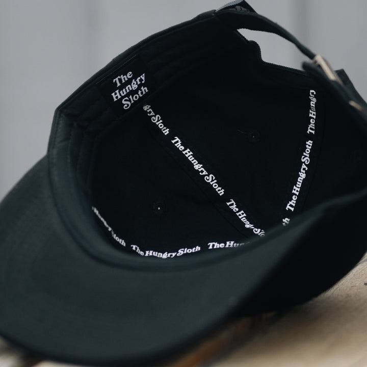 the hungry sloth dad hat in black