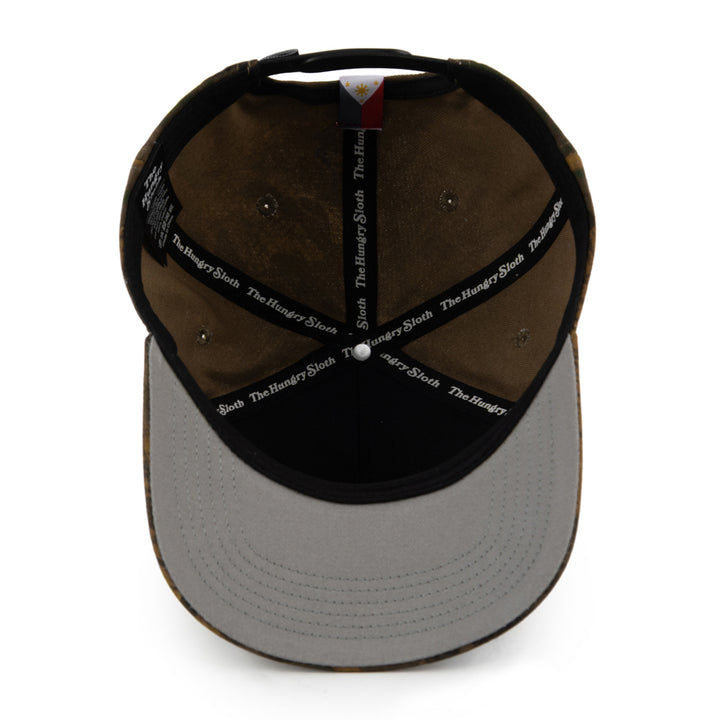 The inside view of a baseball cap showing a brown fabric crown, black brim, black interior straps with the hungry sloth label, and a gray undervisor.