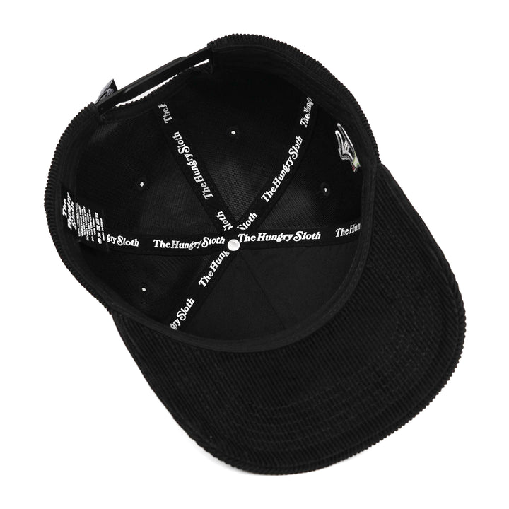 black corduroy snapback hat with the hungry sloth branding underneath