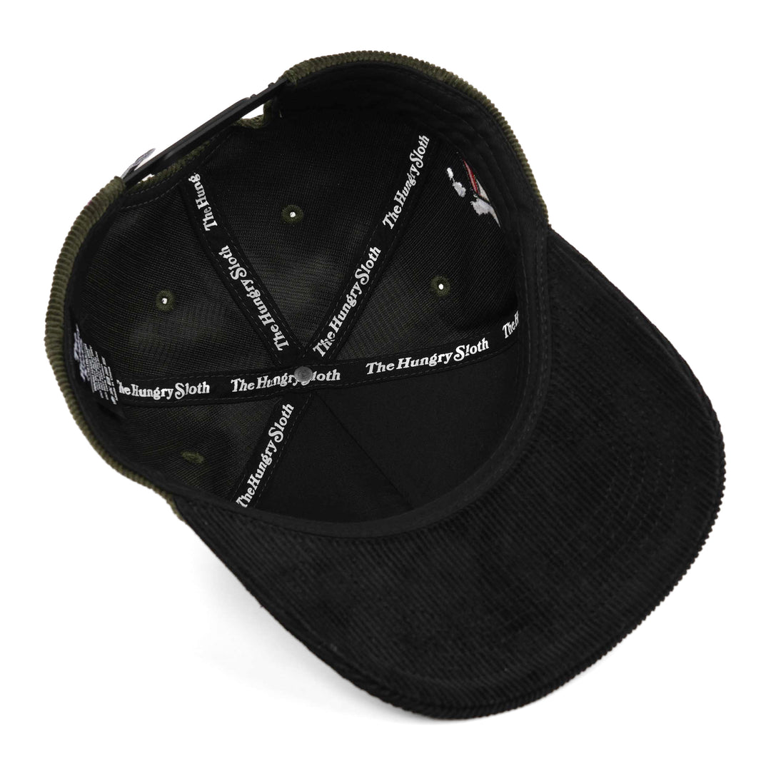 Black corduroy baseball cap shown from an overhead angle, highlighting the interior lining with &